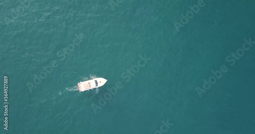 aerial video of a white yacht sailing under a drone in the open sea at a low altitude