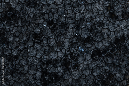 Household dishwashing sponge from reticulated foam, texture, background. Surface of black sponge for washing dishes, pattern closeup