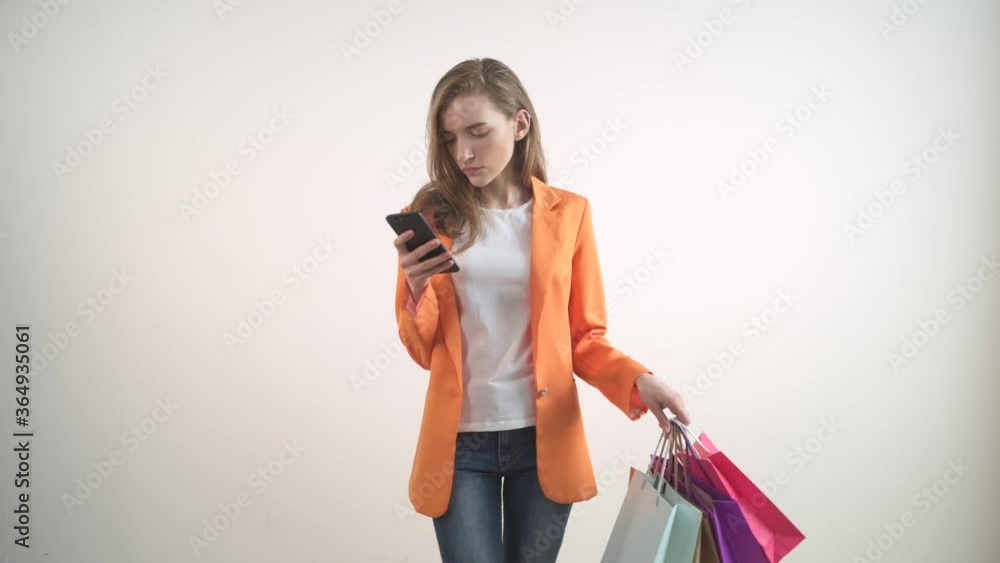 Beautiful young girl is shopping online with a phone in her hands. Beautiful young girl is shopping online with a phone in her hands.