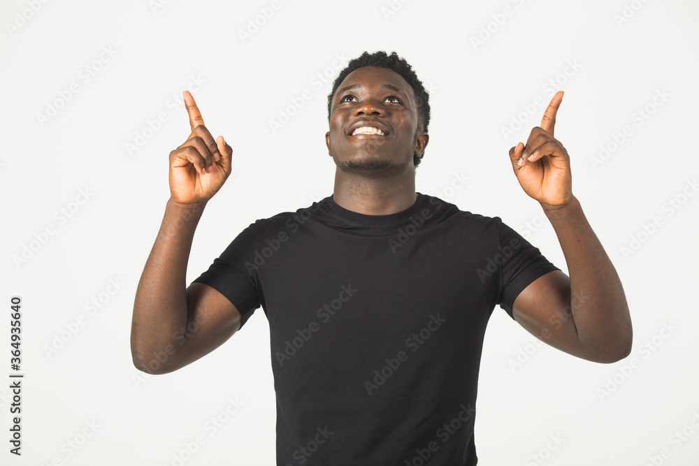 handsome young african male in a black t-shirt on a white background with a smile with a hand gesture handsome young african male in a black t-shirt on a white background with a smile with a hand gesture