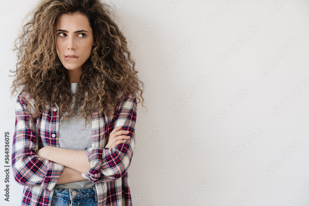 Photo of puzzled beautiful woman looking aside while posing on camera Photo of puzzled beautiful woman looking aside while posing on camera