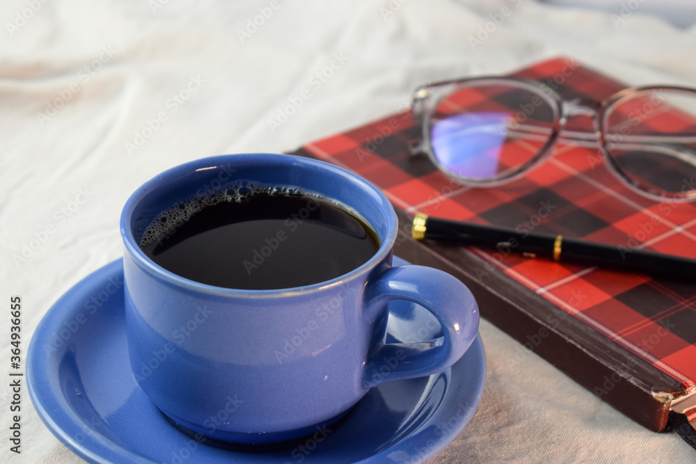 Cup Of Coffee with pen,book and glasses on white background. relax with coffee concept Cup Of Coffee with pen,book and glasses on white background. relax with coffee concept