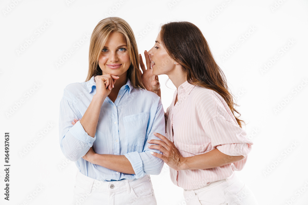 Image of nice brunette woman whispering secret to smiling blonde friend Image of nice brunette woman whispering secret to smiling blonde friend