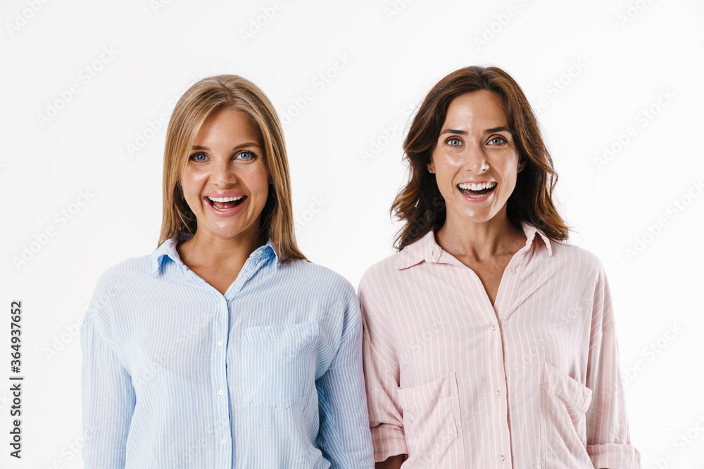Image of excited beautiful two women smiling and looking at camera Image of excited beautiful two women smiling and looking at camera