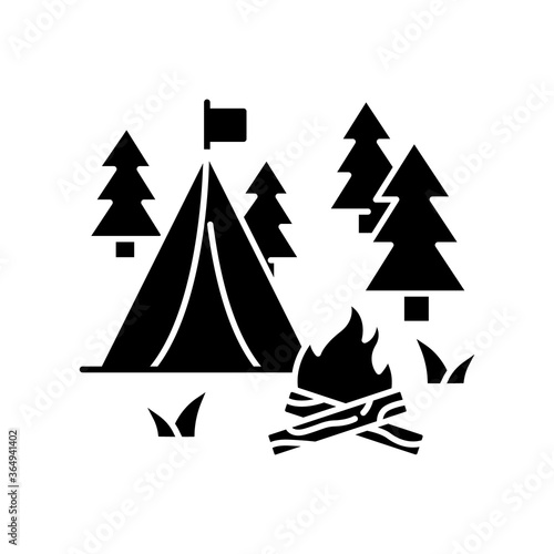 Camping black glyph icon. Nature tourism, outdoor recreation silhouette symbol on white space. Inexpensive vacation, overnight stay in forest. Campfire and tent in woods vector isolated illustration
