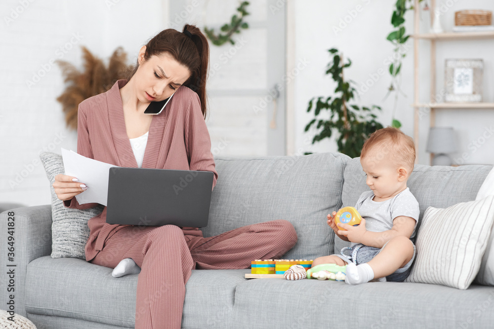Busy Mother Working Remotely At Home While Taking Care Of Baby Busy Mother Working Remotely At Home While Taking Care Of Baby