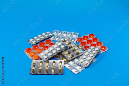 A pile of pills in blister packs. The blister pack is full of multi-colored tablets. A pack of full-color pills. Pharmaceutical blister pack. 