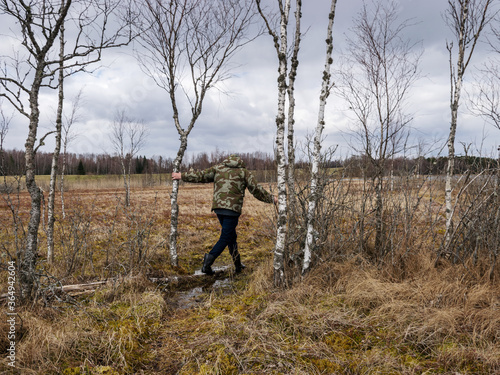 monotonous landscape with a man in a swamp, traditional swamp vegetation in spring