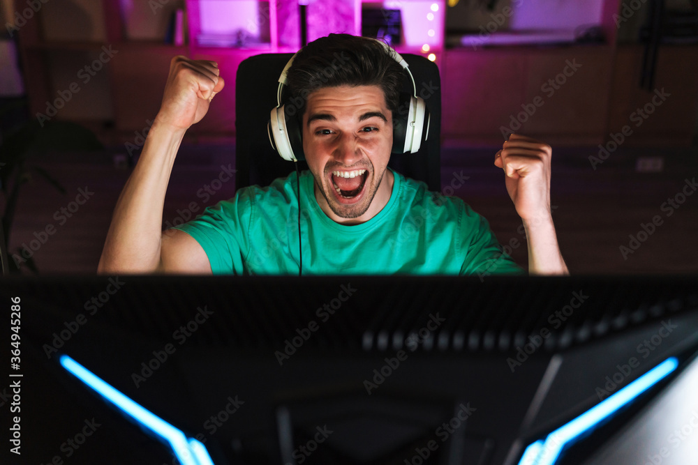 Image of excited man making winner gesture while playing video game Image of excited man making winner gesture while playing video game