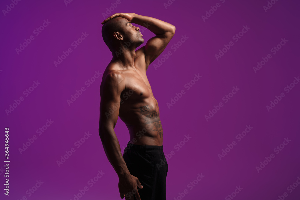 Naklejka premium Image of athletic half-naked african american man posing on camera