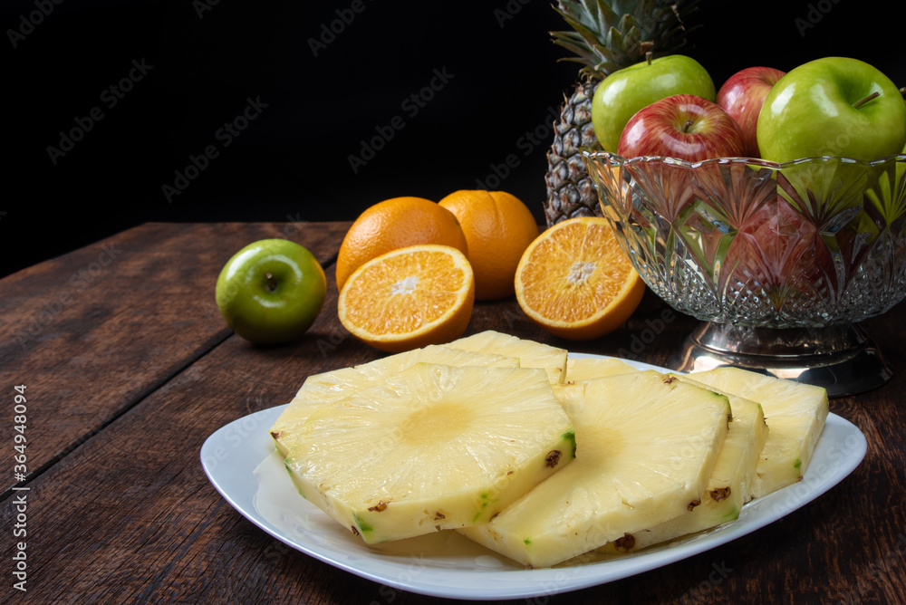pineapple slices in a white crockery on a rustic wooden surface. Selective focus. pineapple slices in a white crockery on a rustic wooden surface. Selective focus.