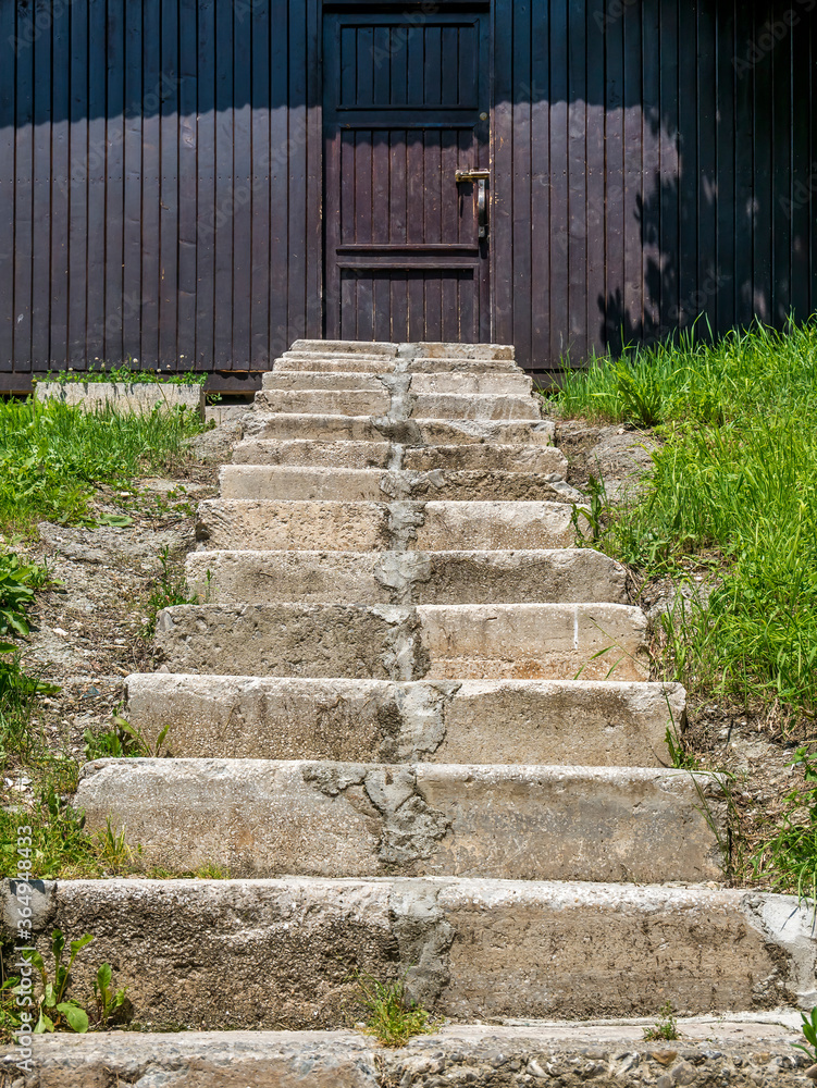 Worn out stone stairs leading to a closed door. Worn out stone stairs leading to a closed door.