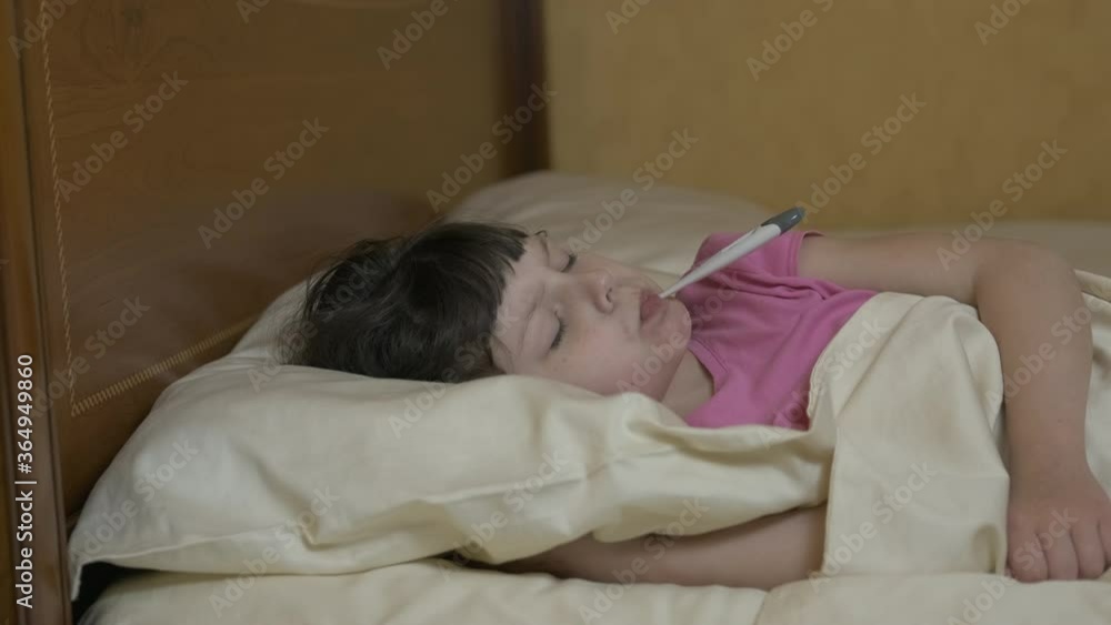 Measuring temperature in the bed. Cute little girls in bed with a thermometer in their teeth. Measuring temperature in the bed. Cute little girls in bed with a thermometer in their teeth.