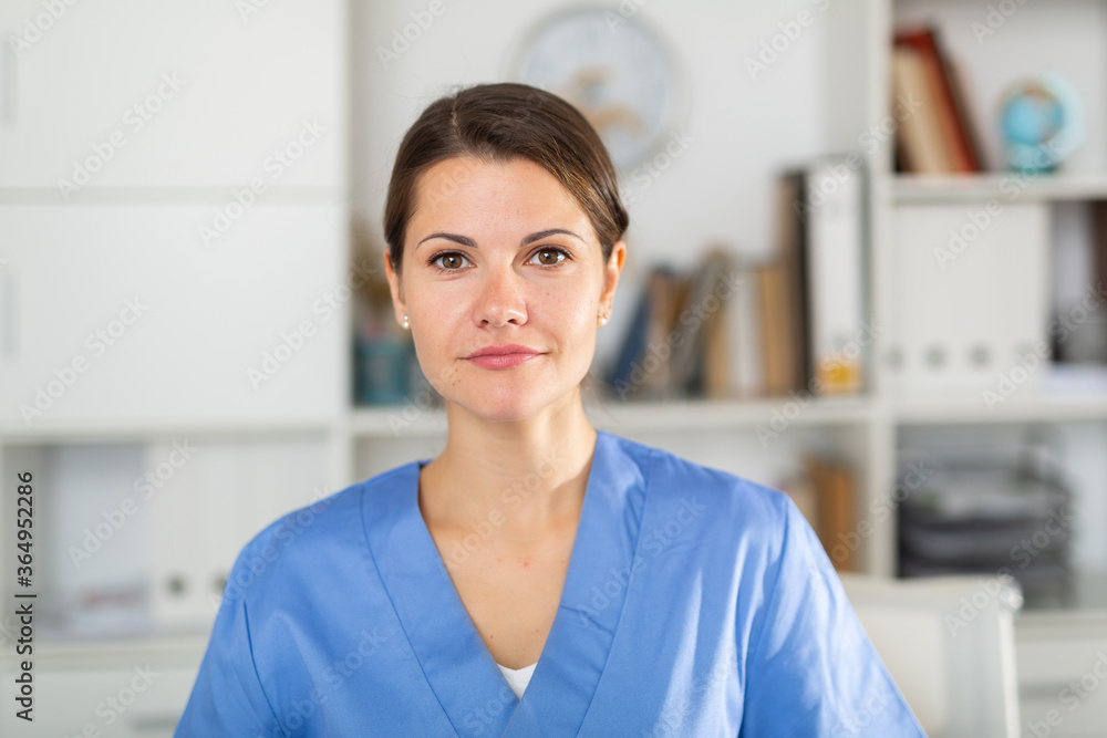 Closeup portrait of smiling female professional health worker in medical office..
