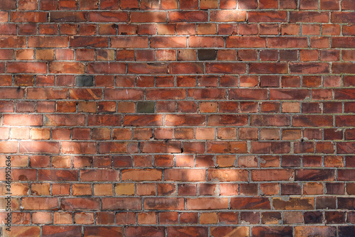 Brick wall background or texture with day light spots.