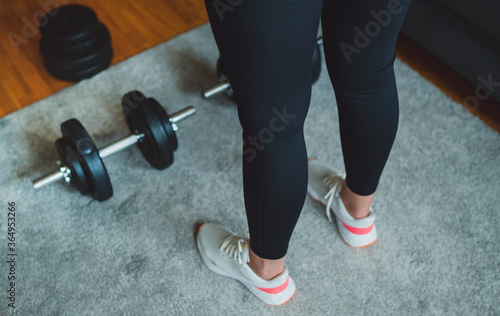 Woman is preparing to work out with dumbbells. Home fitness training concept.