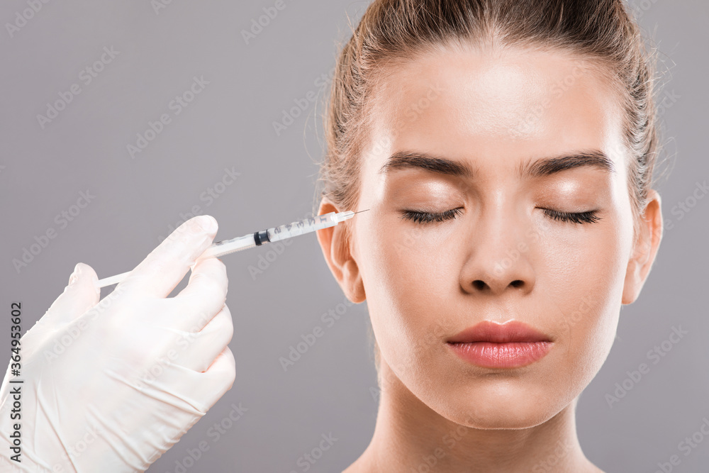 Closeup of young lady having injections for eye wrinkles Closeup of young lady having injections for eye wrinkles
