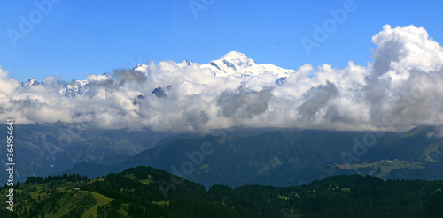 Le Mont Blanc enneigé au dessus des nuages, sur fond de ciel bleu.