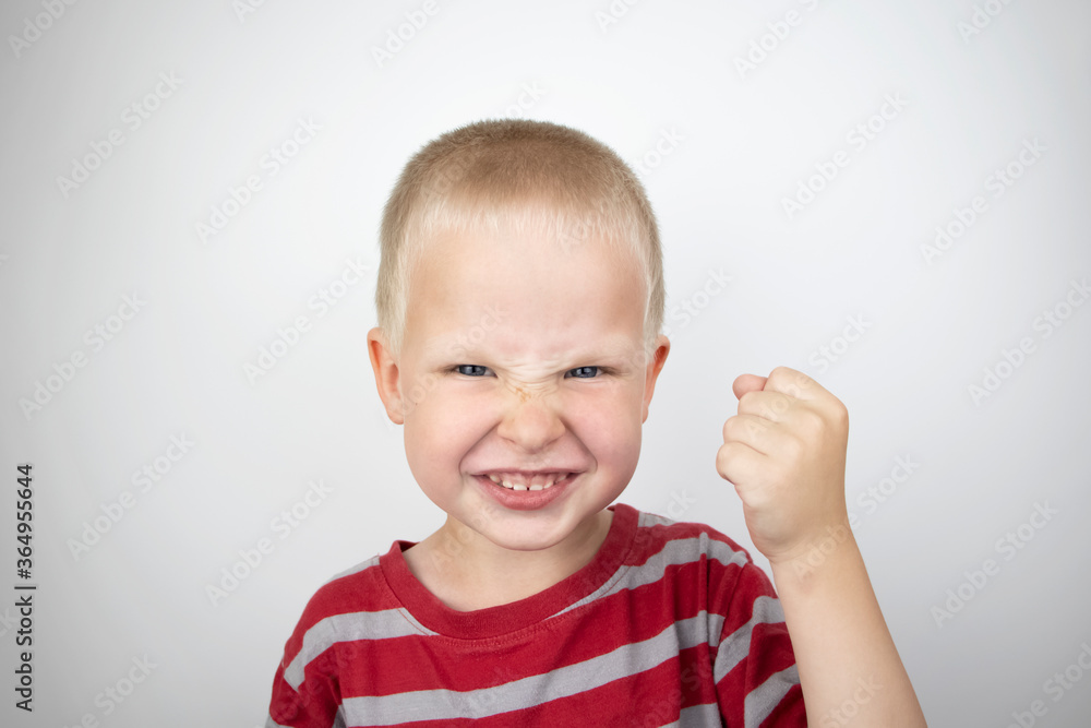 Angry boy screaming and hysteria on a white background. Four-year-old child shows child aggression Angry boy screaming and hysteria on a white background. Four-year-old child shows child aggression