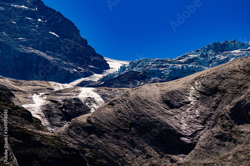 Melting glacier before blank rock with small river and snow. Schmelzender Gletscher Global Warming Rosenlaui Schweiz 