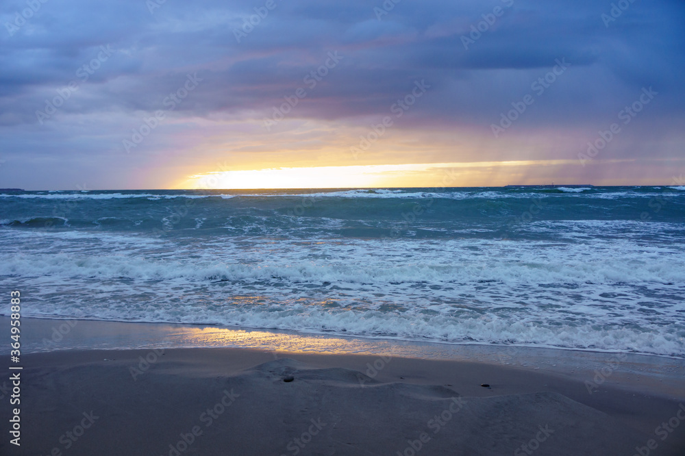 Sunset over the sea. Reflection of sunlight in the sea waves. The sky in the sunset rays. Russia Baltic Sea.