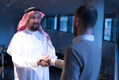 Arab Businessmen's Handshake with American Businessman Descent. Confirmation of Business alliance Partners as WELL. Adhering Respect, Commitment and Integrity in Business Partnership Deal photo