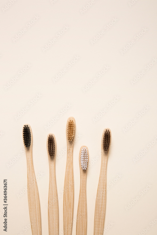 Top view of eco bamboo toothbrushes arranged on cream background Top view of eco bamboo toothbrushes arranged on cream background