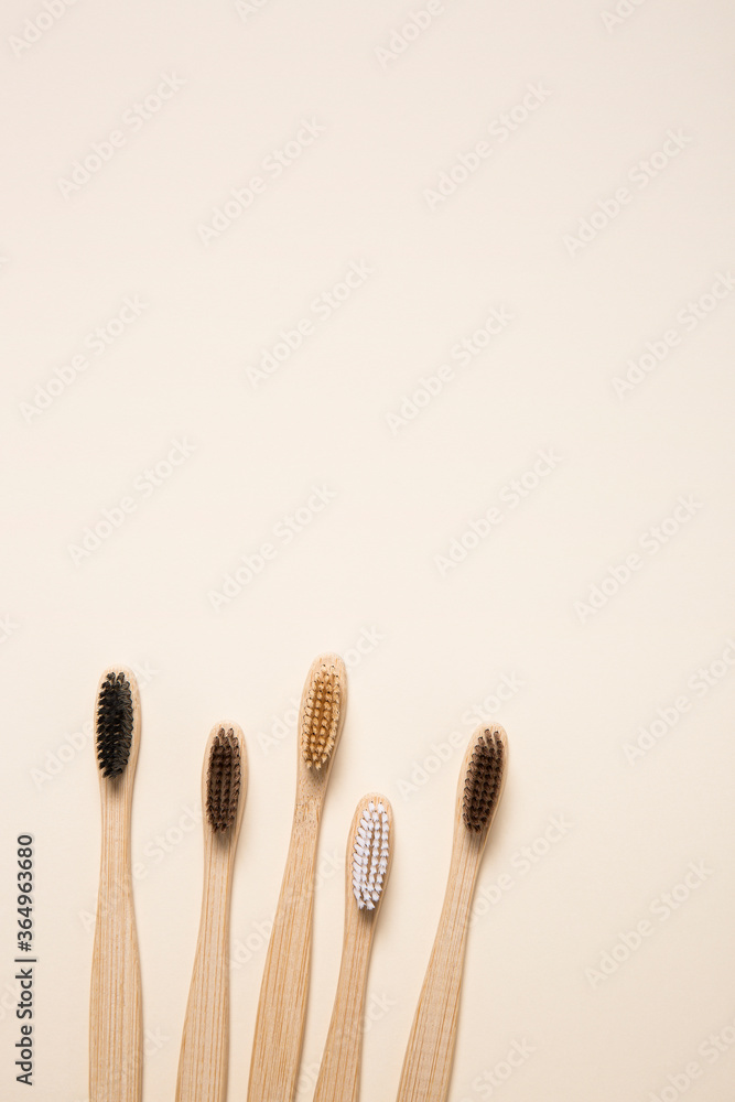 Top view of eco bamboo toothbrushes arranged on cream background Top view of eco bamboo toothbrushes arranged on cream background