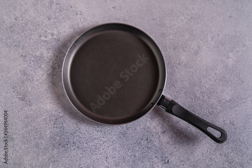 Empty black pan on gray table top view, copy space .