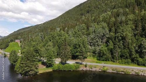 Flying parallel with a road next to the forrest. Small farm nearby photo