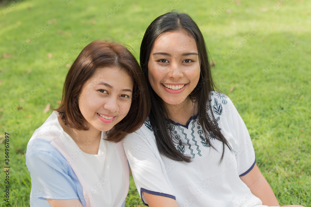 Portrait of two young Asian teenage girls as friends together at the park Portrait of two young Asian teenage girls as friends together at the park