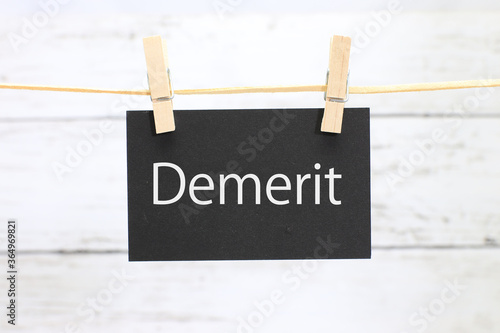 洗濯挟みに吊るされた「demerit」のカード