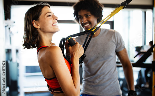 Young beautiful woman doing exercises with personal trainer