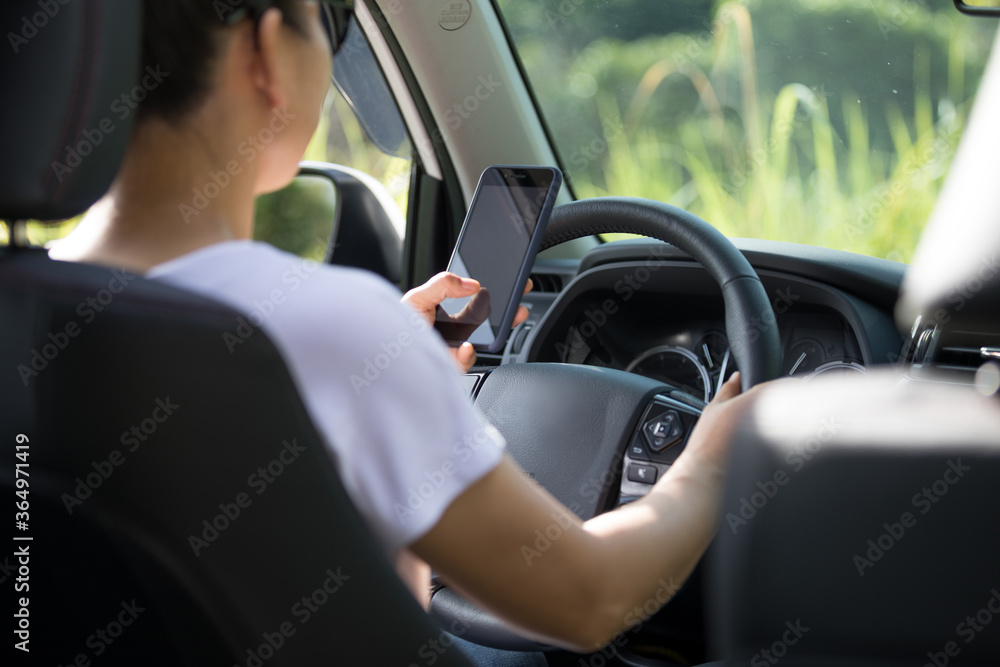 Woman driver using smartphone while driving a off road car in the nature