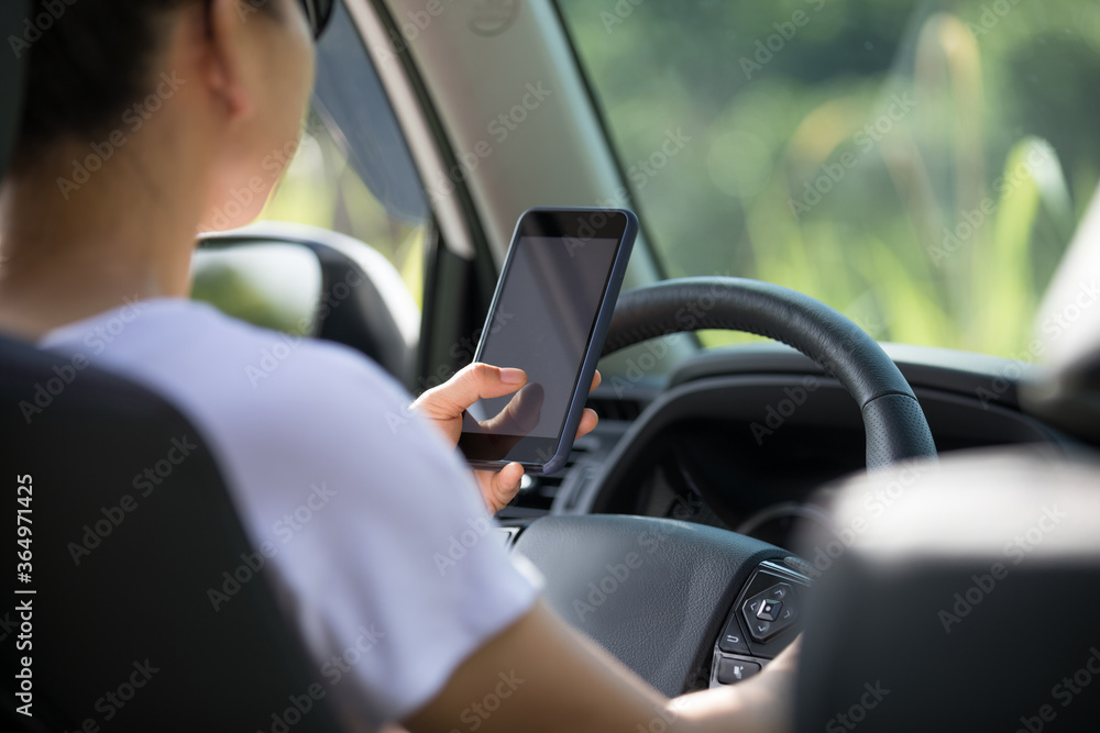 Woman driver using smartphone while driving a off road car in the nature