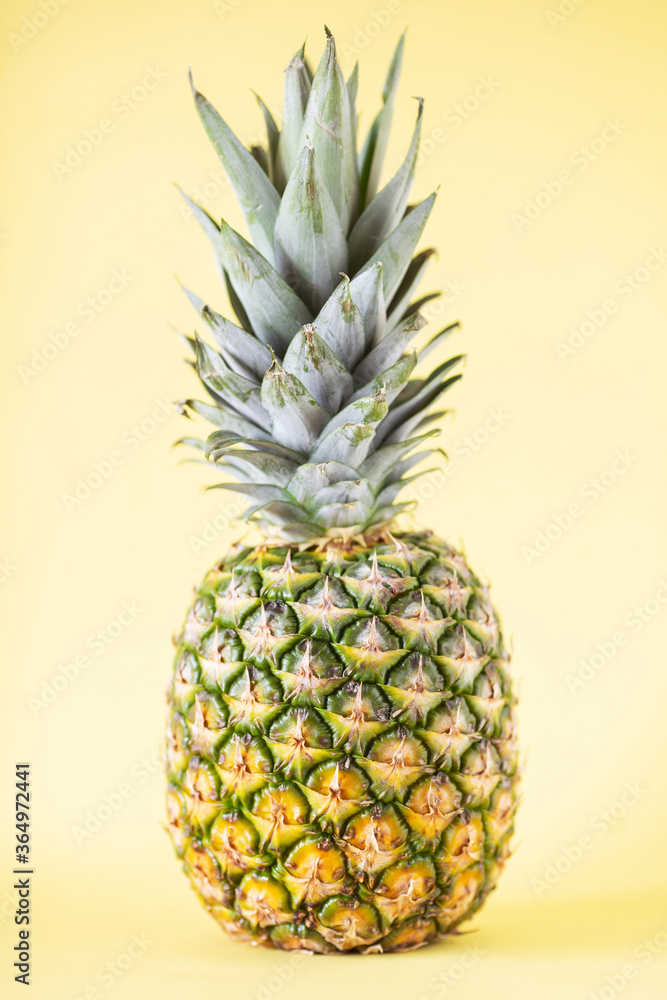 Fresh pineapple on yellow background. Soft focus