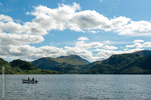 大空と山並み、湖でボートに乗って釣りをするふたり © MANAMI Y Photography