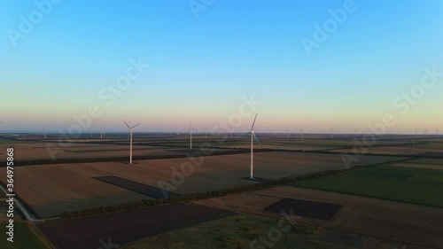 Cinematically smoothly revealing a huge wind turbine park on sunset near Shabla, Bulgaria photo