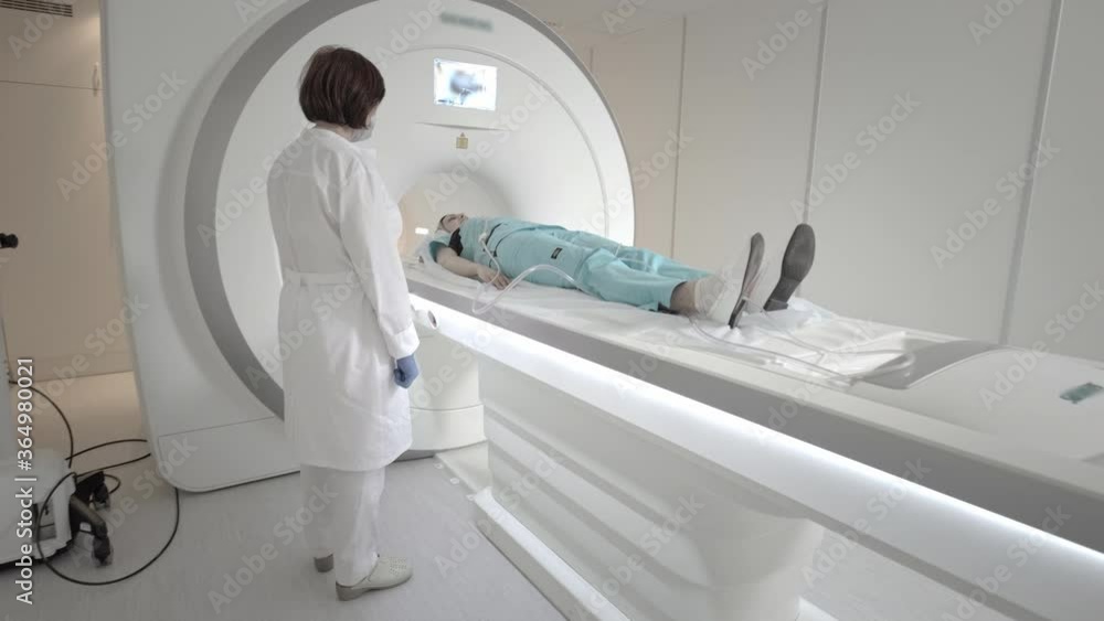 The doctor performs an MRI scan for a patient at the clinic. The girl lies in the MRI device. Magnetic resonance imaging in the study of the human body. Modern technologies in medicine. The doctor performs an MRI scan for a patient at the clinic. The girl lies in the MRI device. Magnetic resonance imaging in the study of the human body. Modern technologies in medicine.