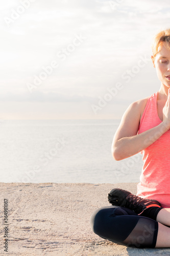 vertical photo of blonde woman doing yoga at dawn © Raul Mellado