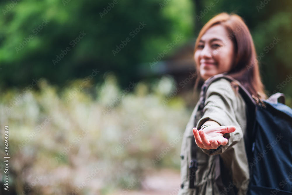 Portrait image of a young female traveler holding hand and lead into mountain stream Portrait image of a young female traveler holding hand and lead into mountain stream