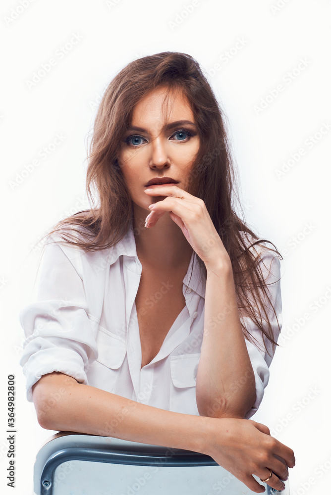 bewitching close-up portrait of a beautiful woman sitting on a chair on a white background in a light shirt bewitching close-up portrait of a beautiful woman sitting on a chair on a white background in a light shirt