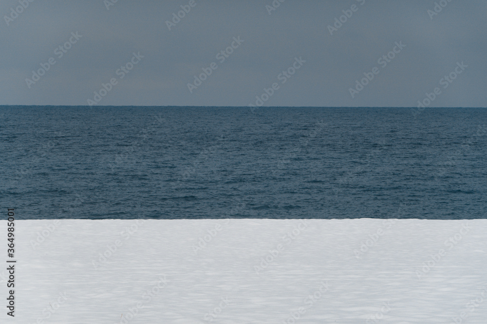 Winter sea. Snowy beach. White and blue.