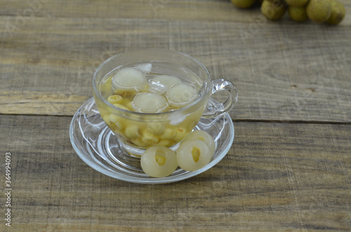 Lotus tea, longan in cup delicious on wooden table photo