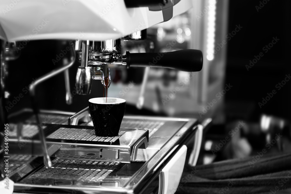 In coffee shop,coffee maker mechine pouring hot fresh coffee into a cup of clear glass cup. In coffee shop,coffee maker mechine pouring hot fresh coffee into a cup of clear glass cup.