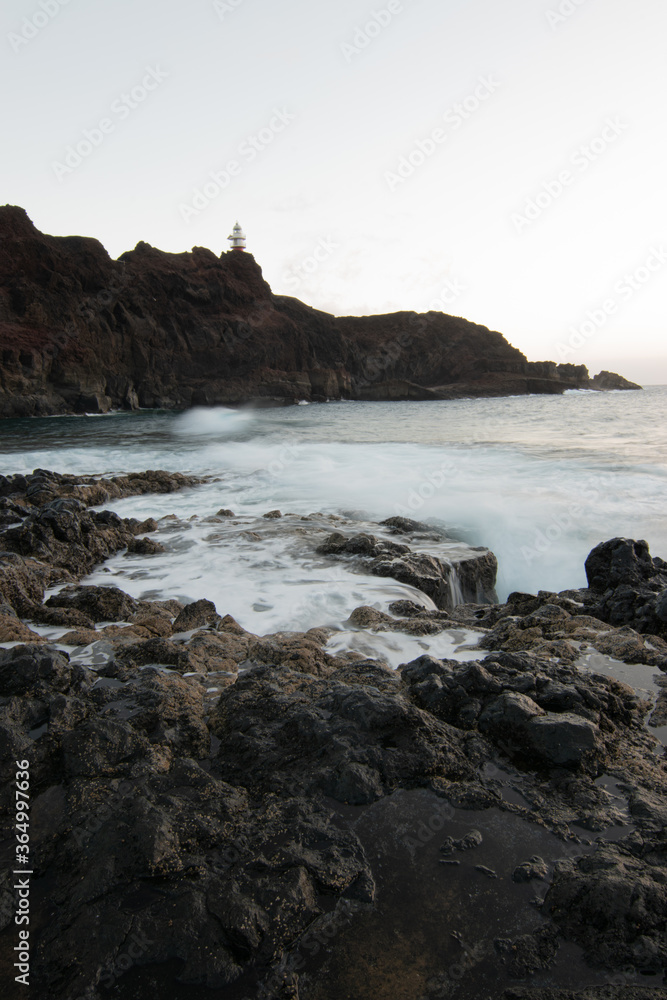 lighthouse on the beach breaking waves