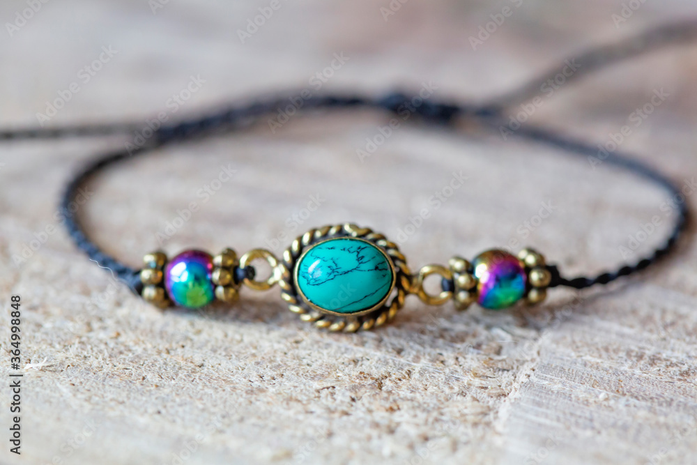 Turquoise and hematite mineral stone beads bracelet on wooden background Turquoise and hematite mineral stone beads bracelet on wooden background