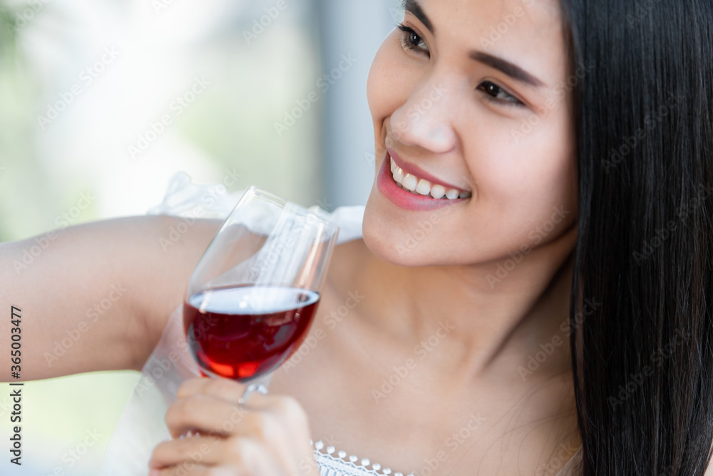 Selfie using a smartphone of Happy of smiling Asian young female sitting at a table food holding with wine glasses at in the restaurant background Selfie using a smartphone of Happy of smiling Asian young female sitting at a table food holding with wine glasses at in the restaurant background