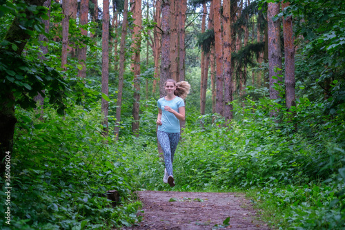 a young beautiful girl runs in a pine forest on a summer morning