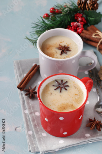 New Year composition with Indian Masala tea with spices in two cups on light blue background, vertical format, Closeup